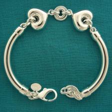 Bracciale semirigido tondo in argento 925. Centrale doppi cuori e maglie tonde.