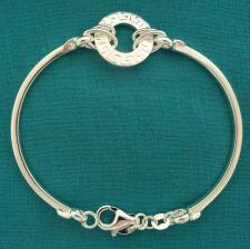 Bracciale semirigido in argento 925 massiccio, maglia tonda centrale con motivo ''greca''.